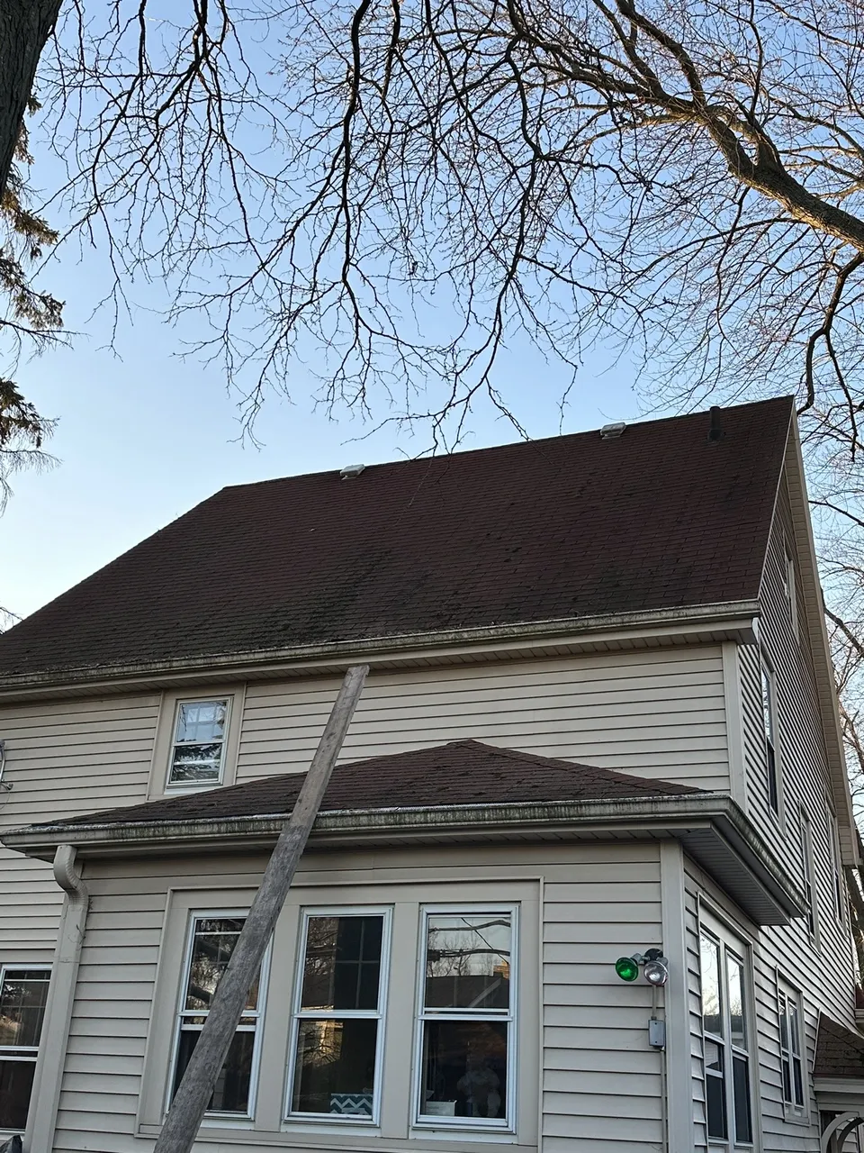 Aging, moss-covered roof before replacement on a Milwaukee home