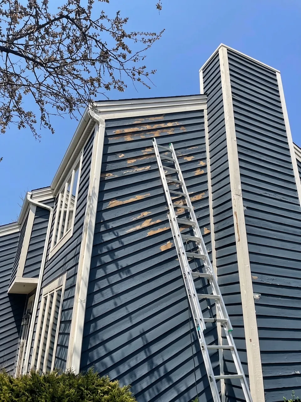 Weathered, peeling siding before exterior painting and repair