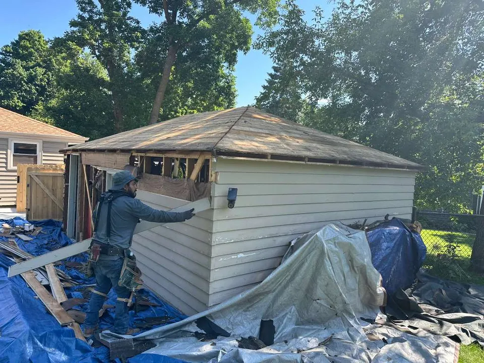 Ultra Roof LLC crew tearing off the old roof and siding on a garage in the Milwaukee area